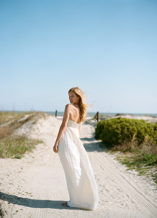 bride looking over back shoulder - sandy pathway leading to the beach -photo by North Carolina wedding photographer Richard Israel 
